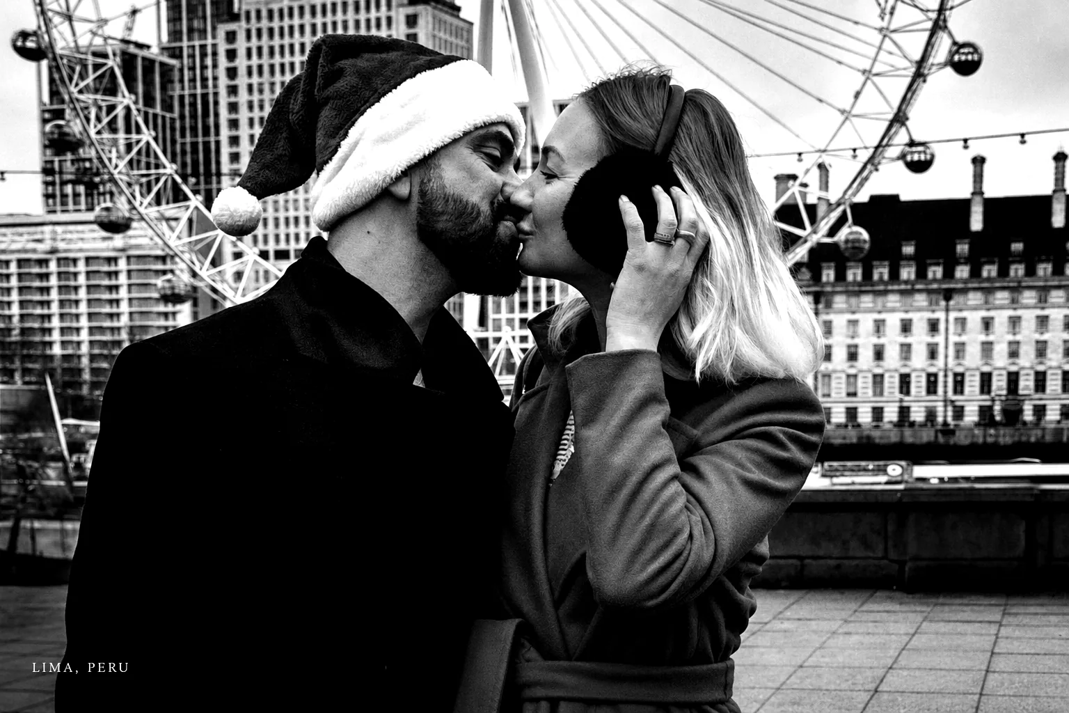 Black-and-white El Beso photograph near a ferris wheel in Lima, Peru.