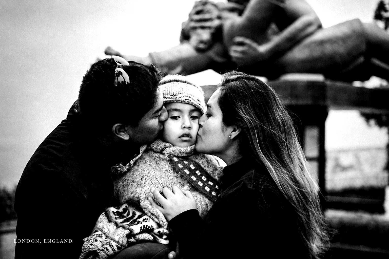 Black-and-white El Beso photograph with family affection in London, England.