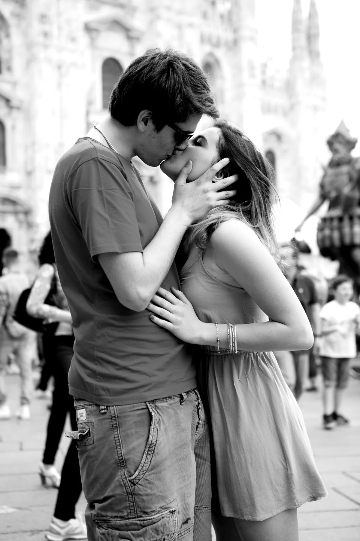 Black-and-white El Beso photograph of a couple kissing in Milan, Italy.